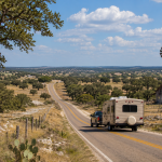Scenic Texas Hill Country road near Florence, Texas with rolling ranchland, live oak trees, and an RV traveling through Central Texas.